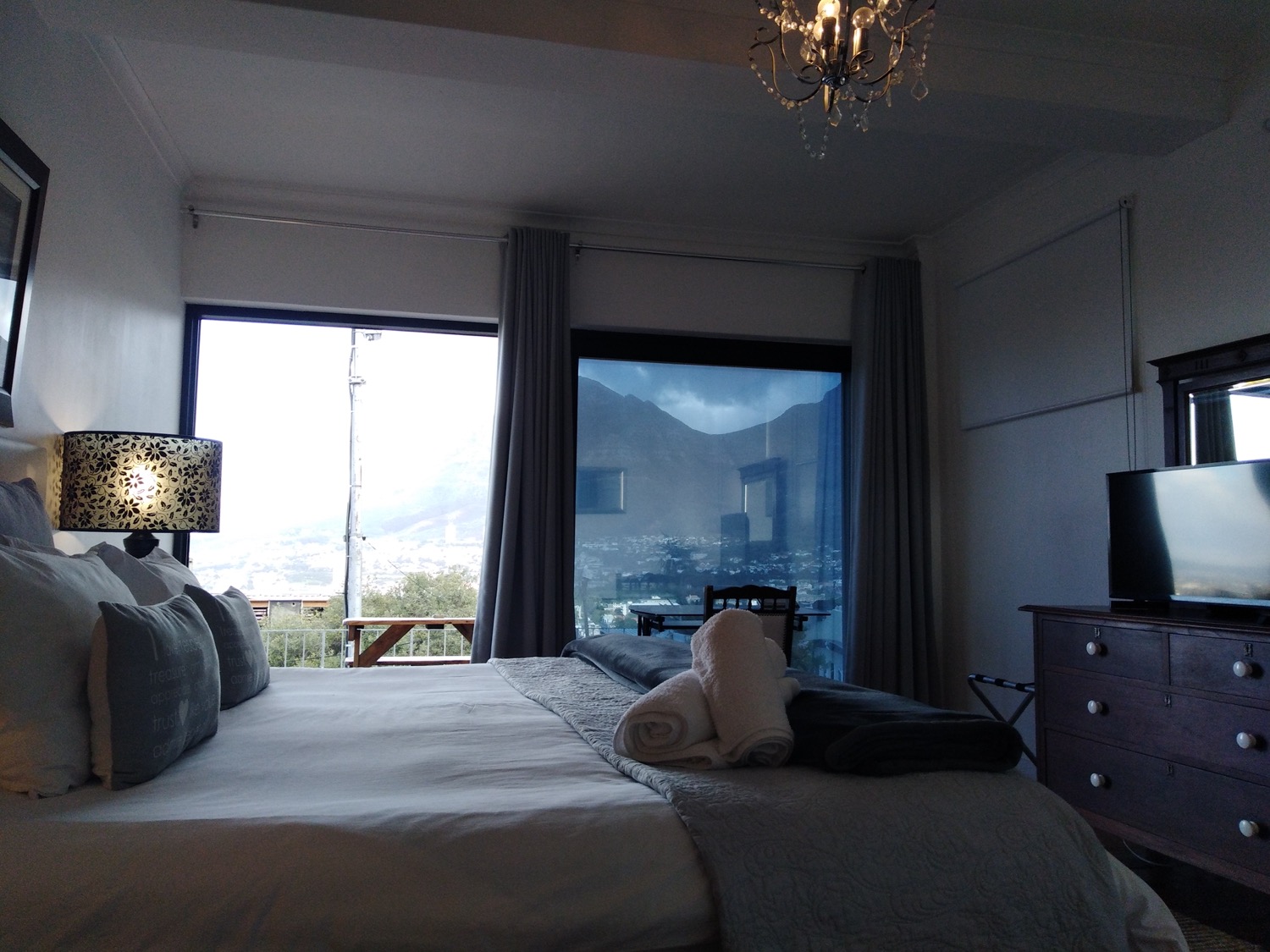 A bedroom with chandelier and mountain view